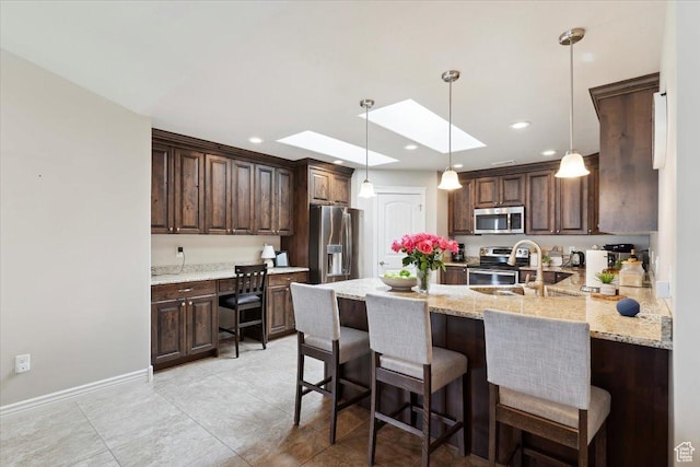1776 W 3025 S, Syracuse, UT 84075 - kitchen with stainless steel appliances, a skylight, dark brown cabinetry, a peninsula, and pendant lighting