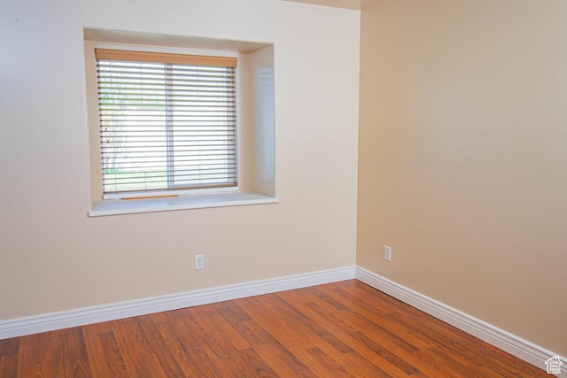 empty room featuring baseboards and wood finished floors