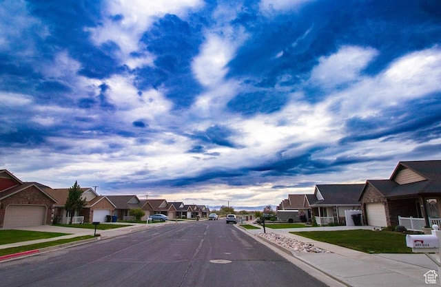 view of asphalt road with a residential view, curbs, and sidewalks