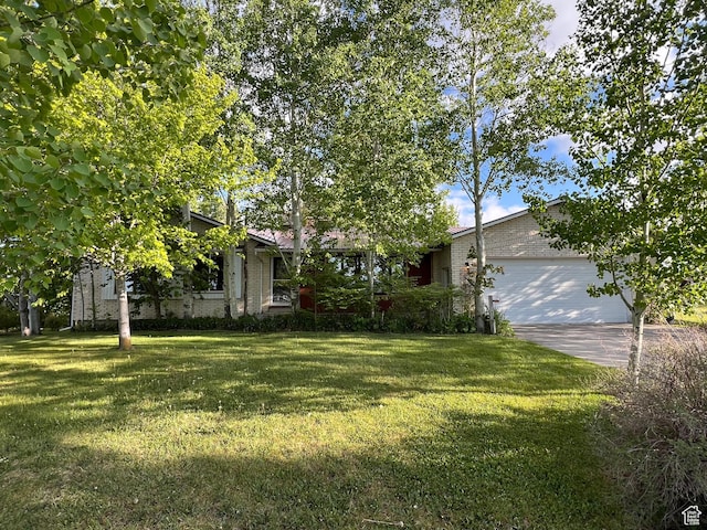 662 N 1600 E, Preston, ID 83263 - view of front of house featuring a garage, a front lawn, concrete driveway, and brick siding