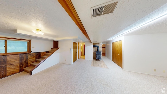 662 N 1600 E, Preston, ID 83263 - basement featuring a wood stove, a textured ceiling, stairway, and carpet flooring