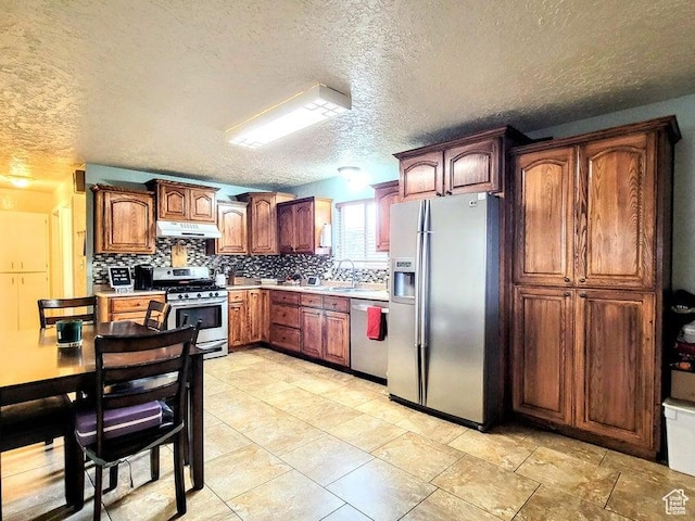273 S 700 W, Parowan, UT 84761 - kitchen featuring stainless steel appliances, under cabinet range hood, backsplash, light countertops, and a textured ceiling