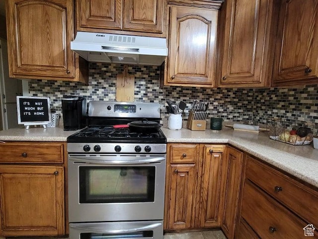 273 S 700 W, Parowan, UT 84761 - kitchen featuring stainless steel gas stove, under cabinet range hood, brown cabinetry, and tasteful backsplash