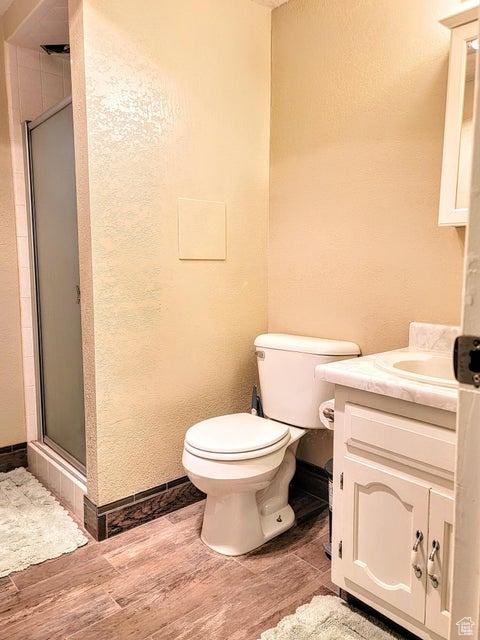 273 S 700 W, Parowan, UT 84761 - bathroom with wood finished floors, a stall shower, toilet, vanity, and baseboards