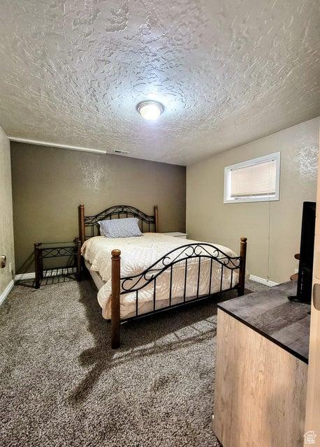 273 S 700 W, Parowan, UT 84761 - bedroom with a textured ceiling, carpet, baseboards, and a textured wall