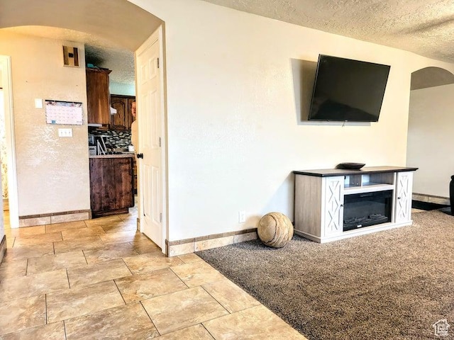 273 S 700 W, Parowan, UT 84761 - unfurnished living room with arched walkways, baseboards, and a textured ceiling