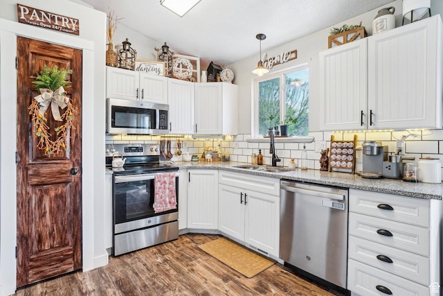 517 E Canyon View Dr N, Ogden, UT 84404 - kitchen featuring appliances with stainless steel finishes, backsplash, lofted ceiling, a sink, and wood finished floors