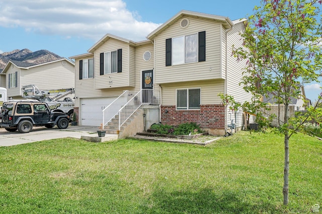 517 E Canyon View Dr N, Ogden, UT 84404 - split foyer home featuring brick siding, driveway, an attached garage, and a front yard