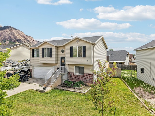 517 E Canyon View Dr N, Ogden, UT 84404 - raised ranch with brick siding, concrete driveway, a garage, and a mountain view