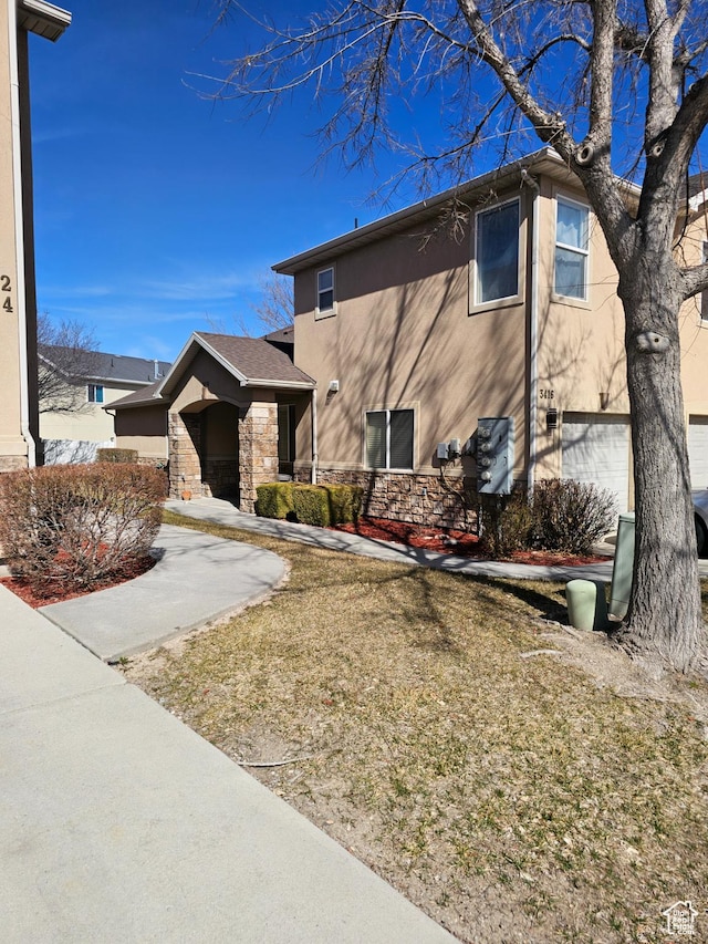 view of front of home featuring stucco siding and stone siding