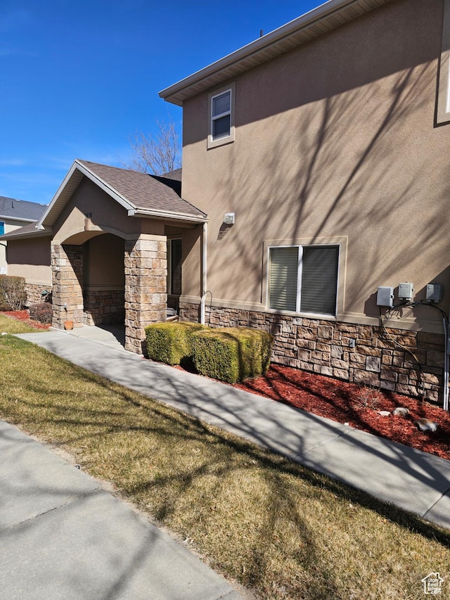 view of property exterior with stone siding and stucco siding