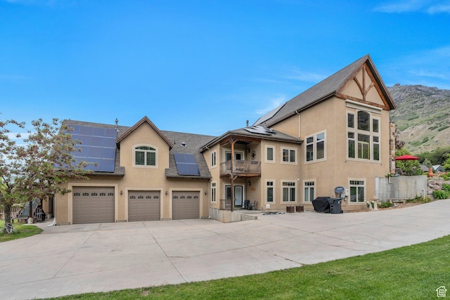 861 N 1100 E, Pleasant Grove, UT 84062 - back of house with a balcony, driveway, stucco siding, a garage, and roof mounted solar panels