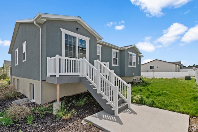 rear view of house with stucco siding and a patio area