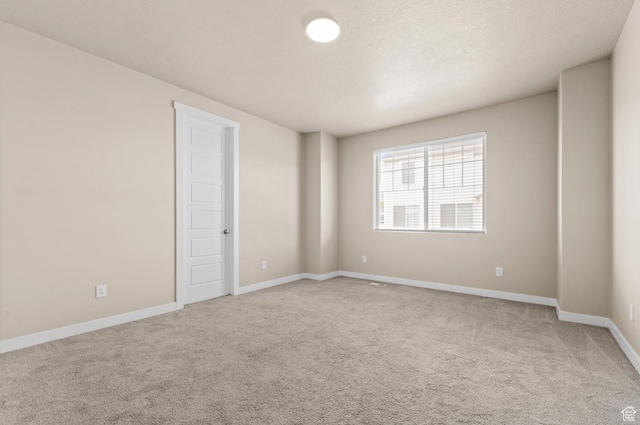 carpeted empty room with baseboards