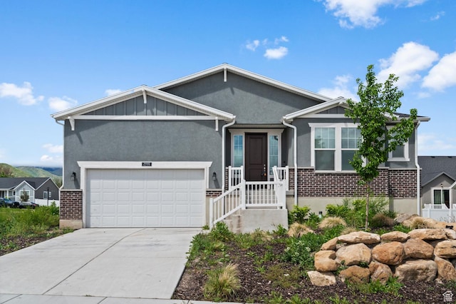 view of front of house featuring brick siding, driveway, stucco siding, and an attached garage