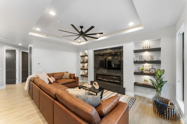 5266 W 2480 S Unit 132, Hurricane, UT 84737 - living room featuring a tray ceiling, light wood finished floors, ceiling fan, a tiled fireplace, and recessed lighting