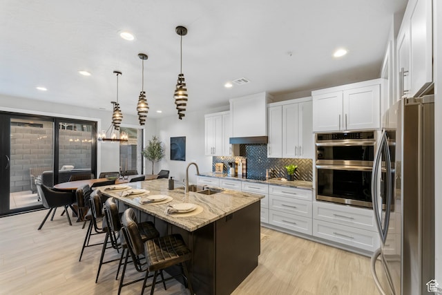 5266 W 2480 S Unit 132, Hurricane, UT 84737 - kitchen with a sink, stainless steel appliances, light stone counters, backsplash, and white cabinets