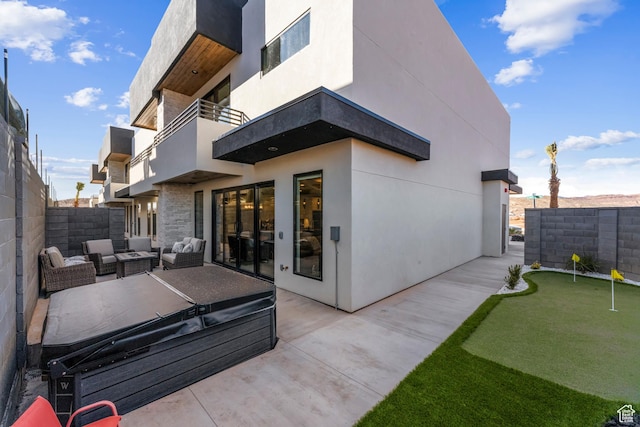 5266 W 2480 S Unit 132, Hurricane, UT 84737 - rear view of property featuring an area to practice putting, a balcony, a patio, a fenced backyard, and an outdoor living space