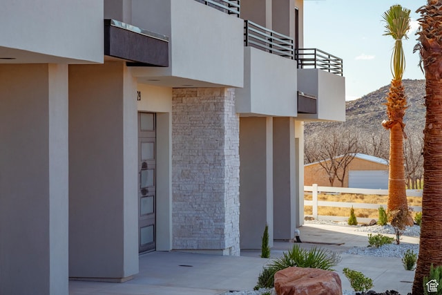 5266 W 2480 S Unit 132, Hurricane, UT 84737 - view of exterior entry featuring a balcony, stone siding, a mountain view, and stucco siding