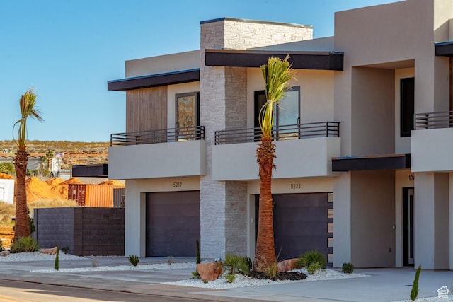 5266 W 2480 S Unit 132, Hurricane, UT 84737 - view of front of home with a balcony, an attached garage, and stone siding