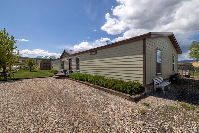 3820 W Main St, Vernal, UT 84078 - view of side of home with a storage unit, an outbuilding, and metal roof