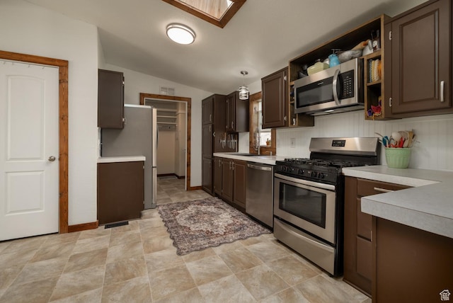 3820 W Main St, Vernal, UT 84078 - kitchen with appliances with stainless steel finishes, light countertops, vaulted ceiling, dark brown cabinetry, and open shelves