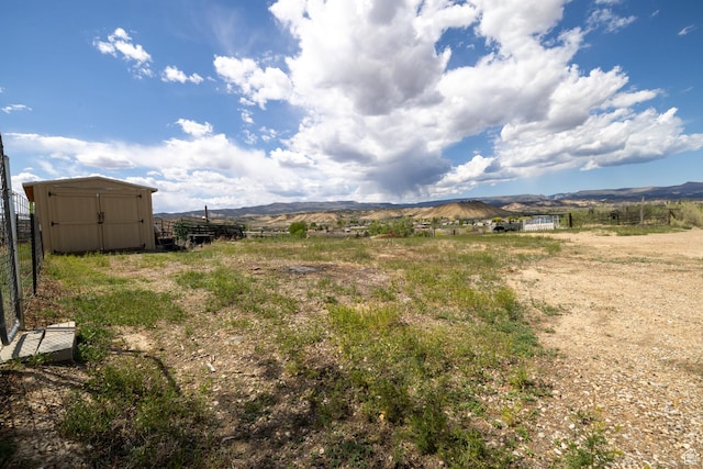 3820 W Main St, Vernal, UT 84078 - view of yard with a storage unit, fence, a mountain view, and an outbuilding