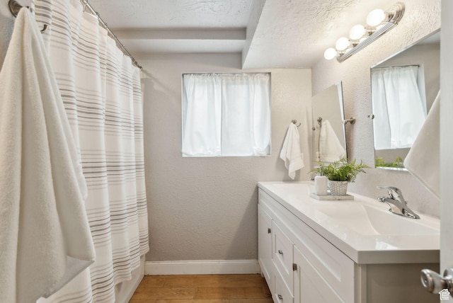 11842 S Elm Ridge Rd E, Sandy, UT 84094 - full bathroom with double vanity, baseboards, wood finished floors, a textured ceiling, and a shower with shower curtain