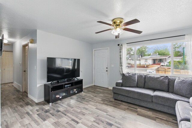 493 N 1025 W St W, Orem, UT 84057 - living room featuring ceiling fan, light wood-type flooring, baseboards, and a textured ceiling