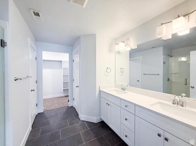 5107 W Harlow Way, Herriman, UT 84096 - bathroom with a shower stall, baseboards, double vanity, tile patterned floors, and a walk in closet