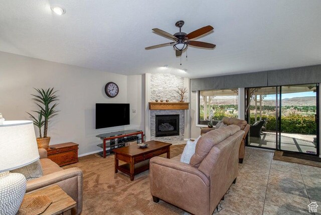 living area featuring a fireplace and ceiling fan