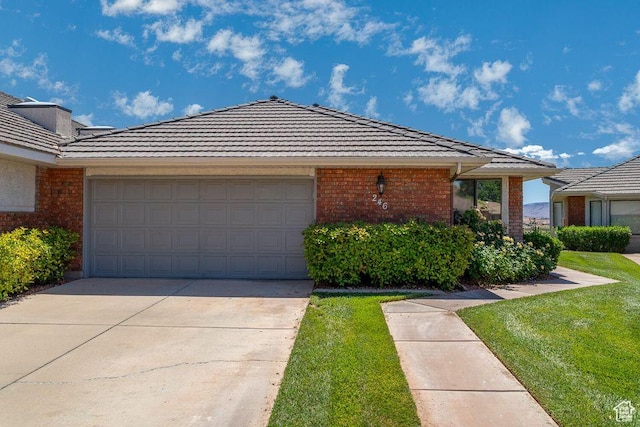 ranch-style house with brick siding, an attached garage, concrete driveway, and a tile roof
