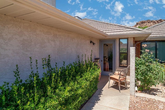 property entrance featuring stucco siding and a tiled roof
