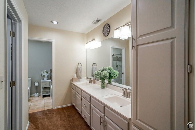 full bathroom with double vanity, toilet, and baseboards