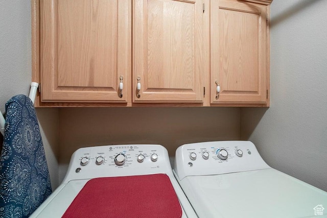 washroom with cabinet space and washer and dryer