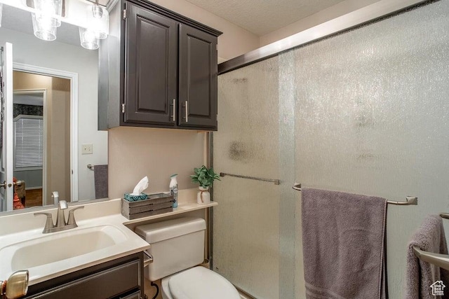 bathroom featuring a stall shower, toilet, and vanity