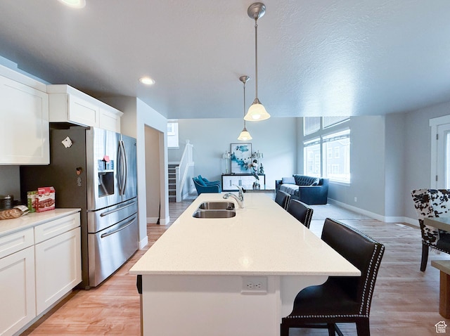 3921 W 1850 N, Lehi, UT 84043 - kitchen with a sink, open floor plan, stainless steel refrigerator with ice dispenser, a kitchen breakfast bar, and baseboards