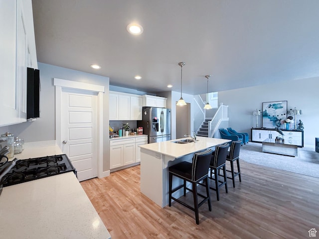 3921 W 1850 N, Lehi, UT 84043 - kitchen with stainless steel fridge with ice dispenser, light wood finished floors, a kitchen bar, light countertops, and white cabinets
