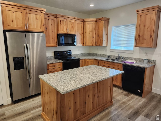 314 E 38th St, South Ogden, UT 84405 - kitchen with black appliances, a sink, light wood-style flooring, light stone countertops, and a center island