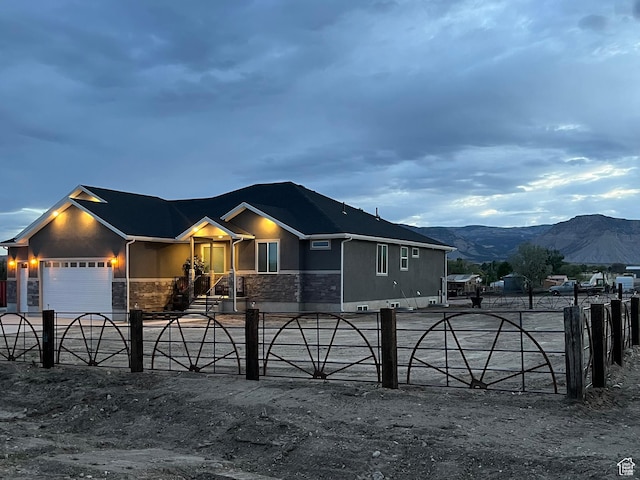 365 N 100 E, Ferron, UT 84523 - view of front of house featuring stone siding, a mountain view, an attached garage, and stucco siding