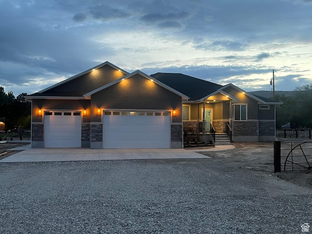 365 N 100 E, Ferron, UT 84523 - view of front of house featuring stone siding, gravel driveway, a garage, and stucco siding