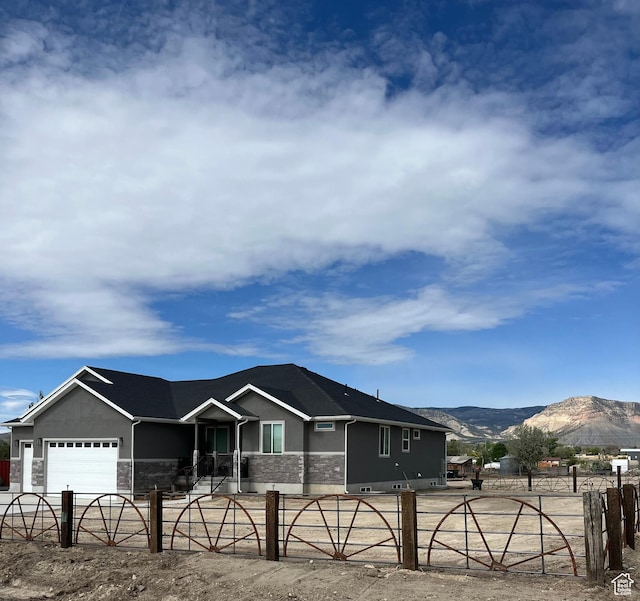 365 N 100 E, Ferron, UT 84523 - ranch-style home with stone siding, a fenced front yard, a mountain view, and a garage