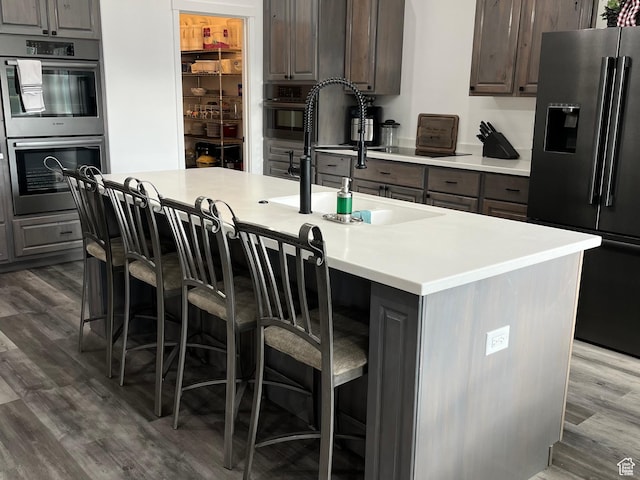 365 N 100 E, Ferron, UT 84523 - kitchen featuring high end fridge, double oven, dark wood-type flooring, light countertops, and a breakfast bar