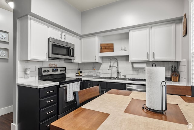 3654 Ogden Ave, Ogden, UT 84403 - kitchen featuring stainless steel appliances, white cabinetry, light countertops, a sink, and dark cabinets