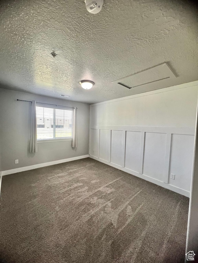 2497 W 500 S Unit 3, Springville, UT 84663 - spare room featuring a textured ceiling, dark carpet, a decorative wall, fire sprinkler in ceiling, and a wainscoted wall