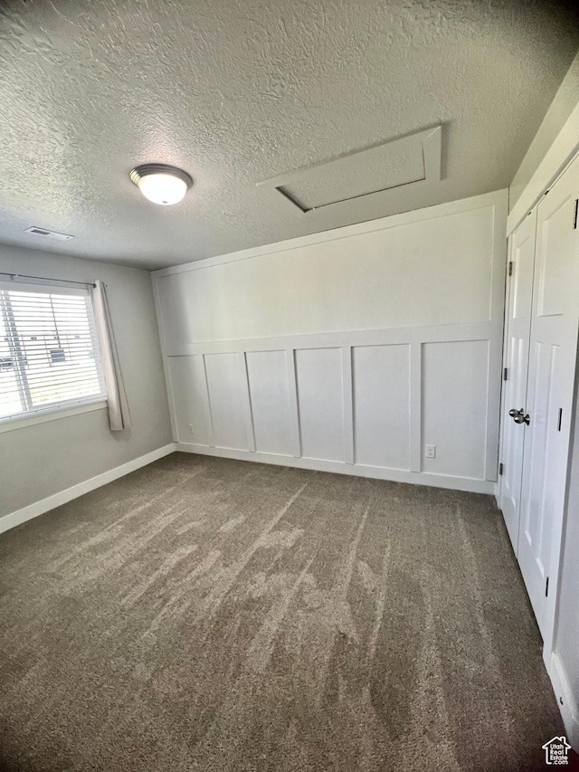 2497 W 500 S Unit 3, Springville, UT 84663 - empty room with carpet, a textured ceiling, a decorative wall, and attic access