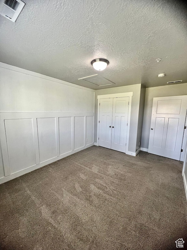 2497 W 500 S Unit 3, Springville, UT 84663 - unfurnished bedroom featuring a textured ceiling, carpet flooring, attic access, a closet, and a decorative wall