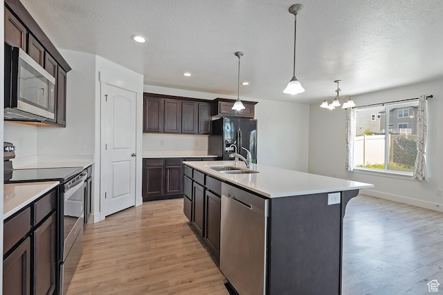 kitchen with stainless steel appliances, light wood-style flooring, light countertops, dark brown cabinetry, and a textured ceiling