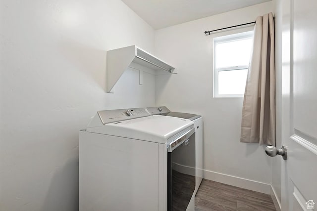laundry room featuring washer and dryer, wood finished floors, and baseboards