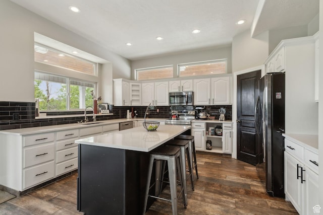 1001 E 1500 N, Layton, UT 84040 - kitchen featuring appliances with stainless steel finishes, a sink, decorative backsplash, a breakfast bar area, and white cabinetry